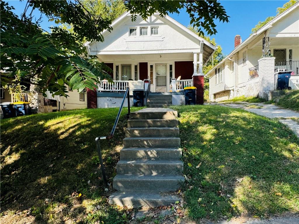 bungalow with a front lawn and covered porch