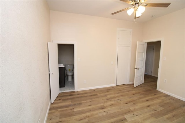 unfurnished bedroom with ensuite bath, ceiling fan, and hardwood / wood-style floors