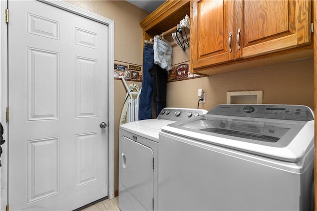 laundry area with cabinets and washing machine and clothes dryer