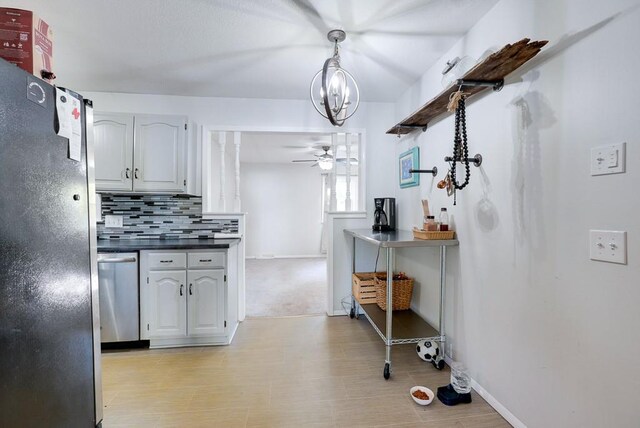 1101 Williams St, Excelsior Springs, MO 64024 - kitchen featuring dishwasher, freestanding refrigerator, dark countertops, backsplash, and a ceiling fan