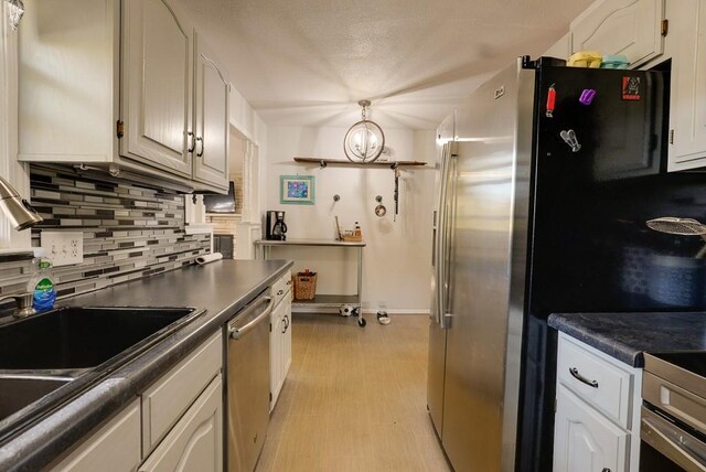 1101 Williams St, Excelsior Springs, MO 64024 - kitchen featuring stainless steel appliances, decorative backsplash, dark countertops, and baseboards