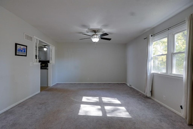 carpeted spare room featuring ceiling fan