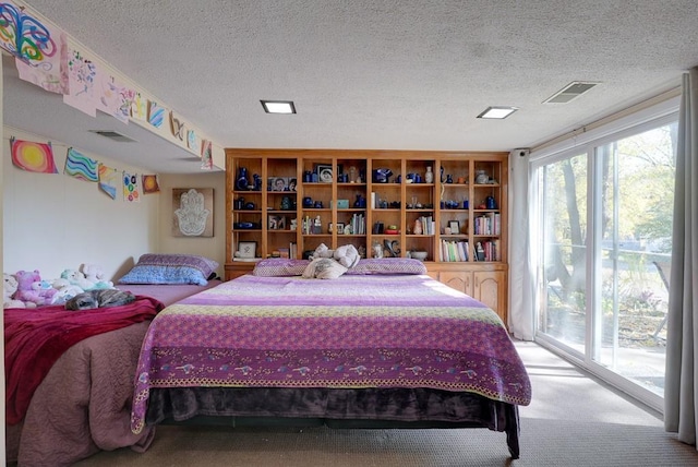 carpeted bedroom with a textured ceiling and access to exterior