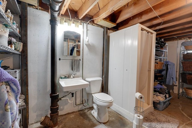 bathroom featuring toilet, concrete flooring, and sink