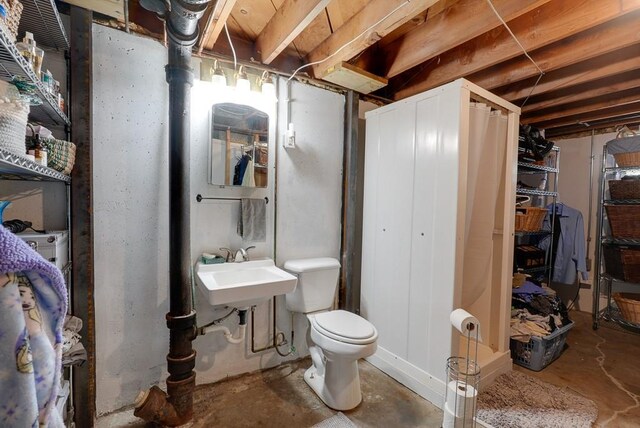 1101 Williams St, Excelsior Springs, MO 64024 - bathroom featuring unfinished concrete flooring, toilet, and a sink