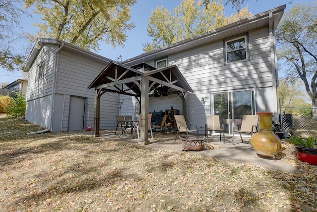 rear view of property with a patio and a fire pit