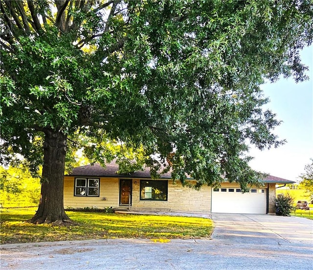 single story home featuring a garage and a front lawn