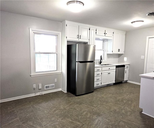 kitchen with tasteful backsplash, white cabinetry, sink, and stainless steel appliances