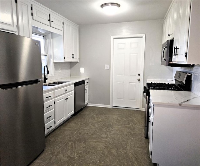 kitchen featuring white cabinets, appliances with stainless steel finishes, backsplash, and sink