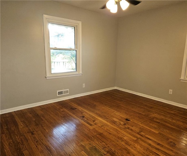 empty room with ceiling fan and dark wood-type flooring