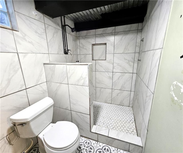 bathroom with toilet, tile walls, and tiled shower