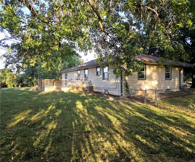 exterior space with a deck, a yard, and central AC