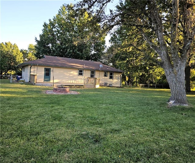 rear view of property with a deck and a yard