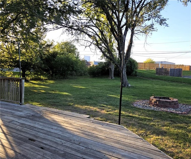 wooden terrace with a yard and an outdoor fire pit