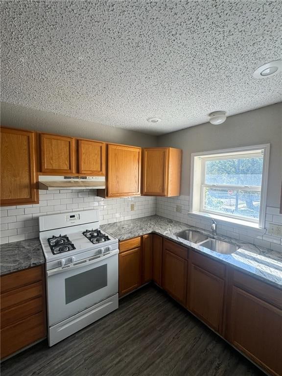 kitchen featuring sink, backsplash, white range with gas cooktop, and dark hardwood / wood-style floors