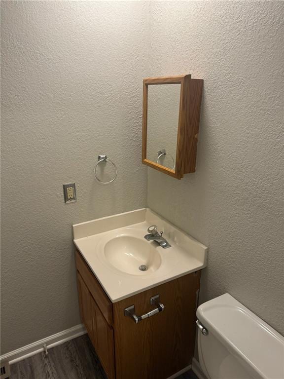 bathroom featuring vanity, hardwood / wood-style floors, and toilet