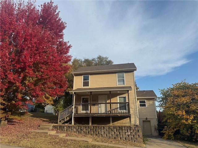 back of property featuring covered porch