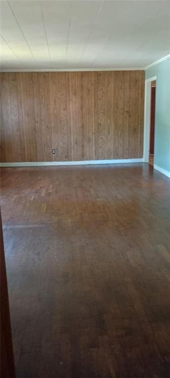 spare room with wooden walls and dark wood-type flooring