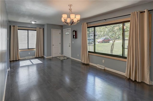 foyer with a chandelier, dark hardwood / wood-style floors, and a healthy amount of sunlight