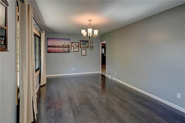 unfurnished dining area with dark hardwood / wood-style floors and an inviting chandelier