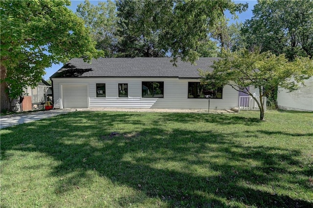 back of house with a yard and a garage