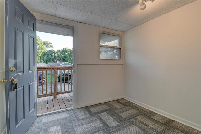 entryway featuring dark carpet and a drop ceiling