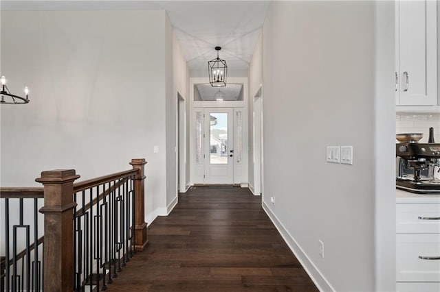 corridor with a chandelier and dark wood-type flooring