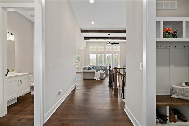 hall with dark hardwood / wood-style flooring and beamed ceiling