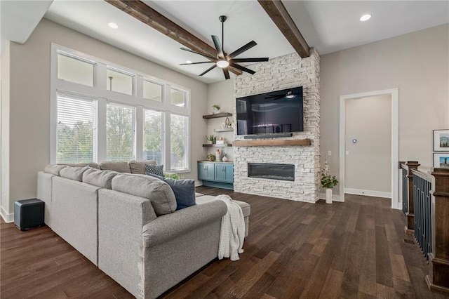 living room with a stone fireplace, dark hardwood / wood-style flooring, beamed ceiling, and ceiling fan