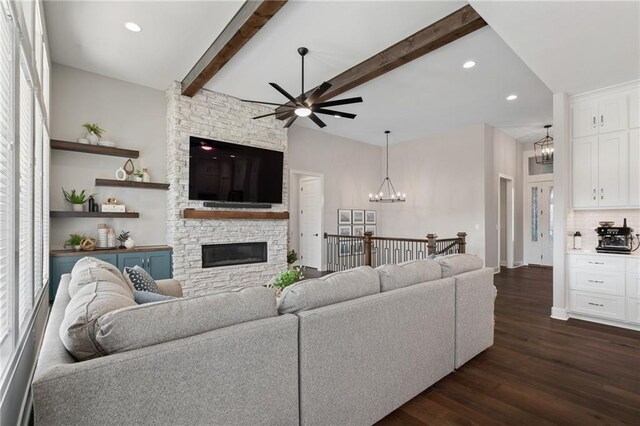 living room featuring a stone fireplace, beamed ceiling, dark hardwood / wood-style floors, and a healthy amount of sunlight