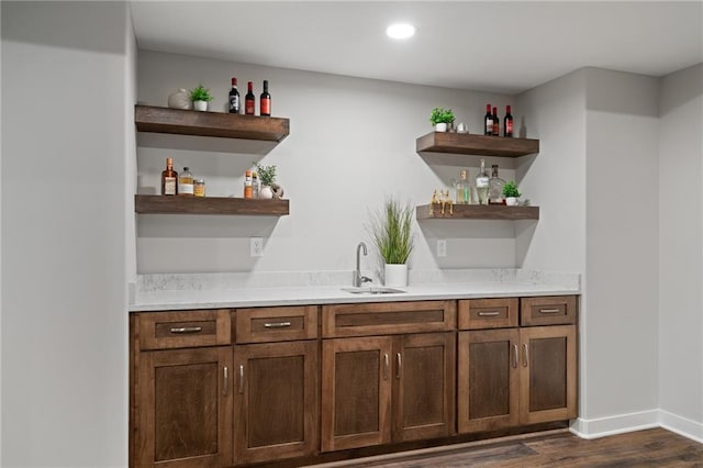 bar featuring sink and dark wood-type flooring