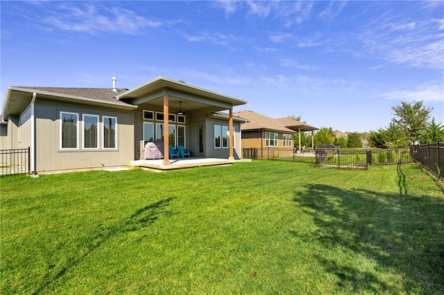 back of house featuring a lawn, ceiling fan, and a patio area