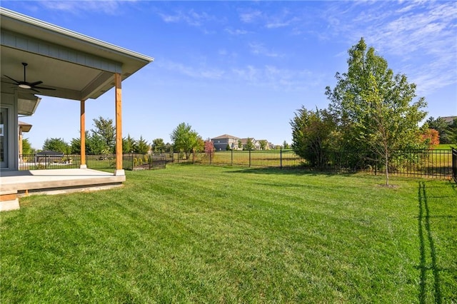 view of yard with ceiling fan and a patio