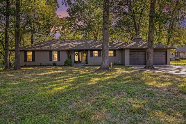 ranch-style home with a lawn and a garage