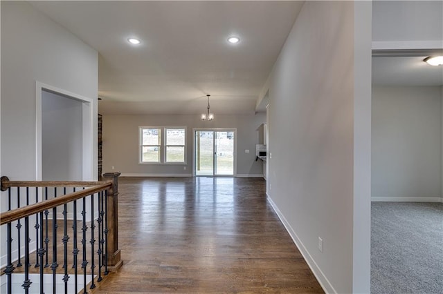 spare room with recessed lighting, a notable chandelier, dark wood-style flooring, baseboards, and vaulted ceiling