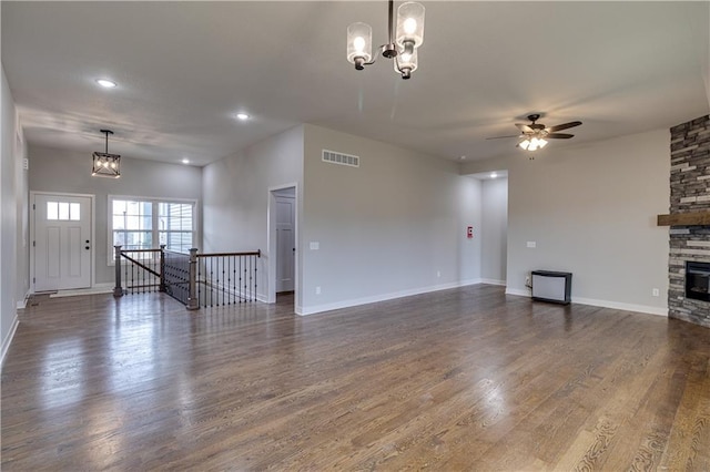 unfurnished living room with dark wood-type flooring, a fireplace, visible vents, and baseboards