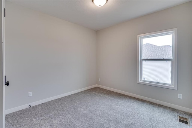 empty room featuring carpet, visible vents, and baseboards