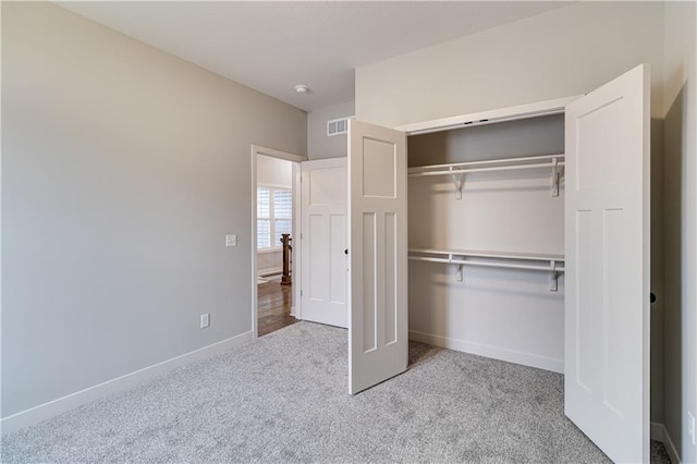 unfurnished bedroom featuring carpet floors, a closet, visible vents, and baseboards