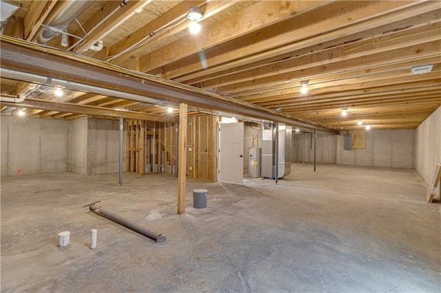 unfinished basement featuring electric water heater and heating unit