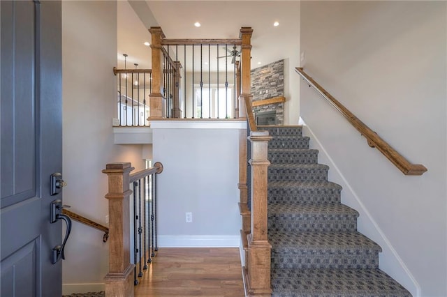 staircase featuring wood-type flooring and a fireplace