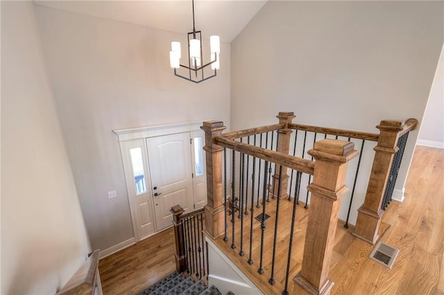 foyer featuring a notable chandelier, hardwood / wood-style floors, and lofted ceiling