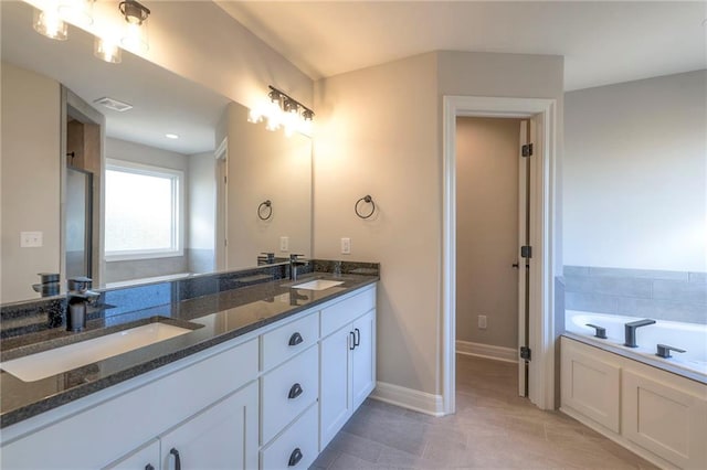 bathroom featuring vanity, a tub, and tile patterned floors