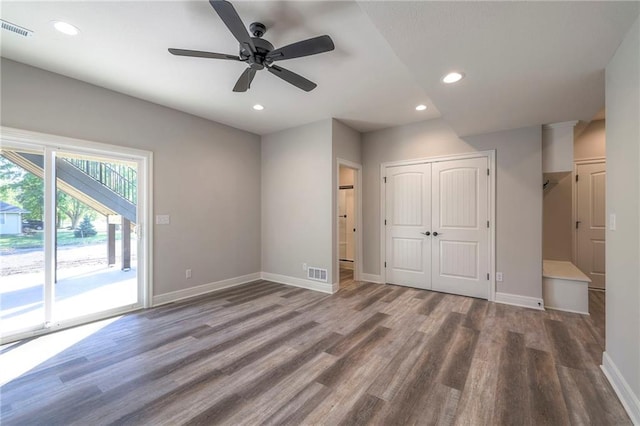 unfurnished bedroom with a closet, access to exterior, hardwood / wood-style flooring, and ceiling fan