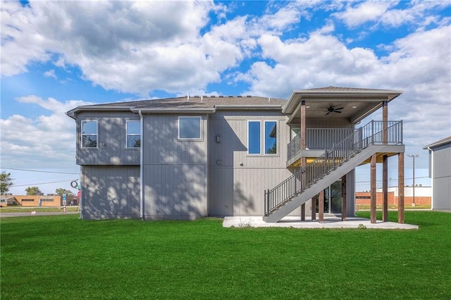 rear view of property with a lawn and ceiling fan