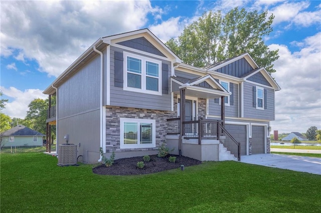 view of front of house with a front yard, central AC, and a garage