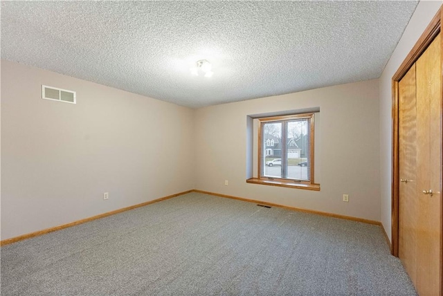 empty room with visible vents, light carpet, baseboards, and a textured ceiling