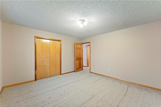 unfurnished bedroom featuring light carpet, a closet, and baseboards