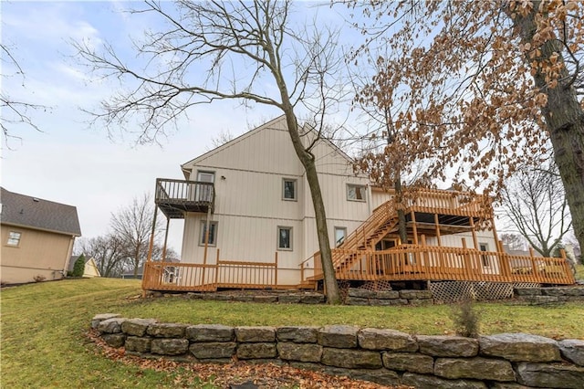 rear view of property featuring a lawn, a deck, and a balcony