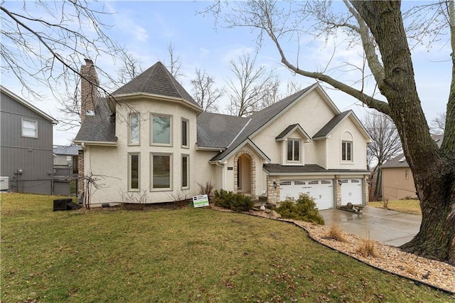 view of front facade with concrete driveway, a chimney, an attached garage, a front lawn, and stucco siding