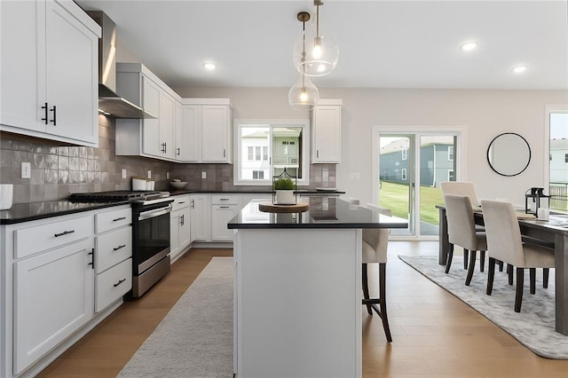 13424 W 178th St, Overland Park, KS 66013 - kitchen featuring stainless steel gas stove, wall chimney exhaust hood, dark countertops, a kitchen island, and tasteful backsplash